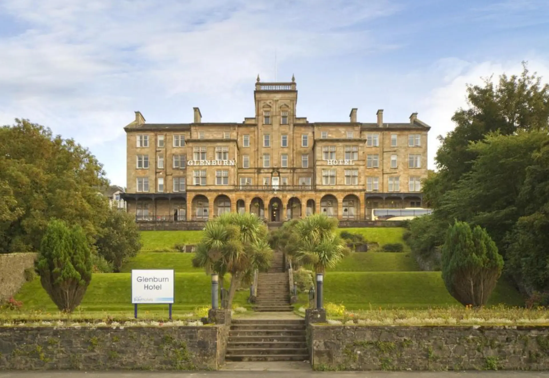 The Glenburn Hotel, a large sandstone building set above lawns and palm trees in Rothesay
