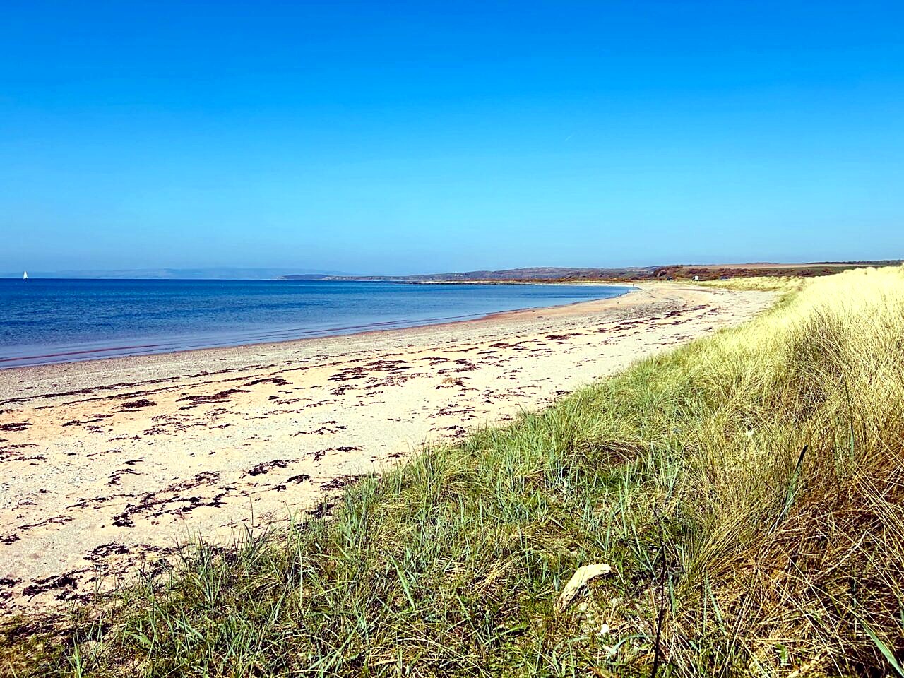 Stravanan Bay on the Isle of Bute, with pale sand, marram grass dunes and the Arran hills on the horizon